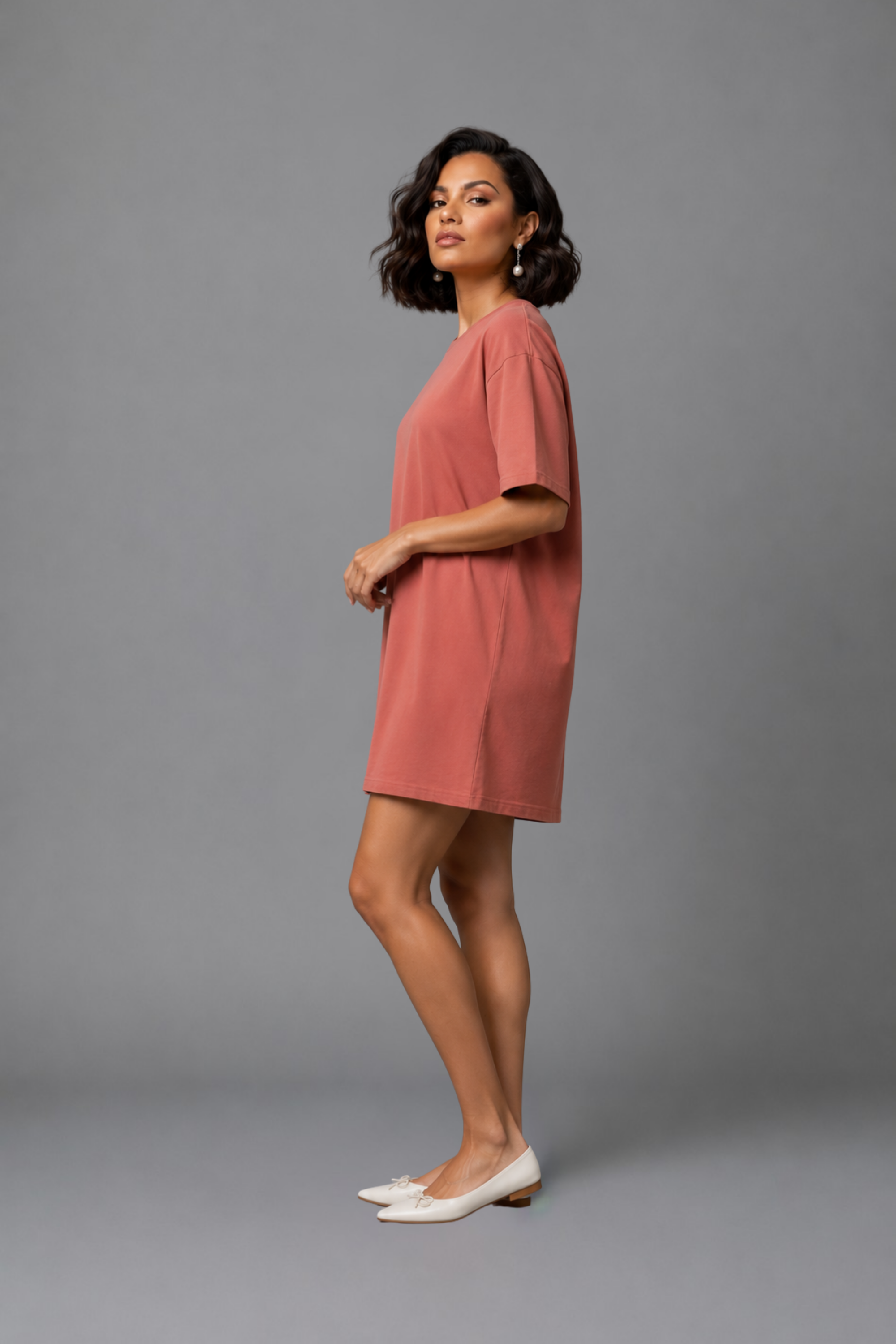 Side profile of a woman modeling the Snug Oversized Dress in Dusky Mauve, highlighting the comfortable half-sleeves and elevated loungewear style. #color_Coral