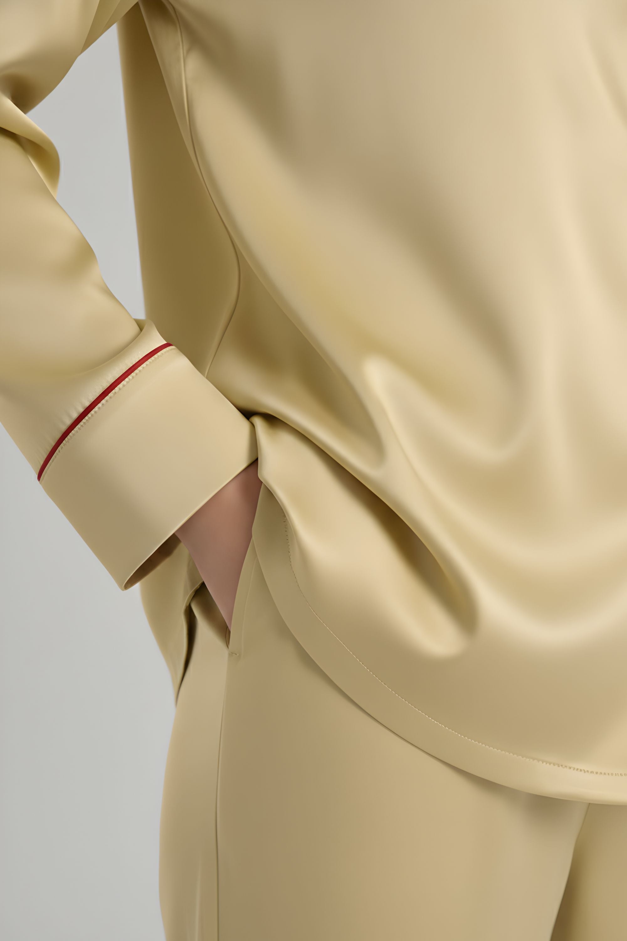 Close-up of pocket detail and sleeve cuff on Koye satin pajama top. #color_Butter Yellow
